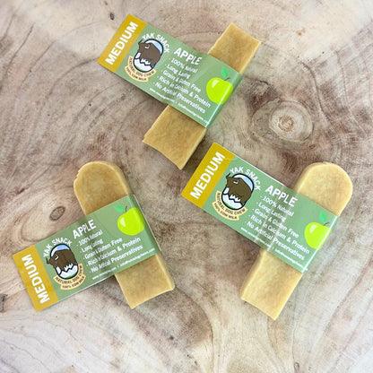 Four dog treats with labels on a wooden surface