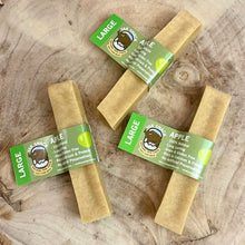 Three large apple treats with green labels on a wooden surface