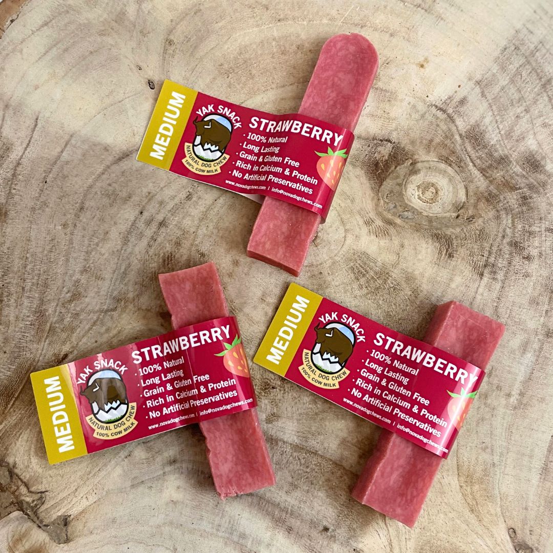 Strawberry-flavored dog treats with packaging on a wooden surface