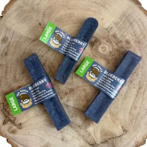 Blueberry dog treats with labels on a wooden surface
